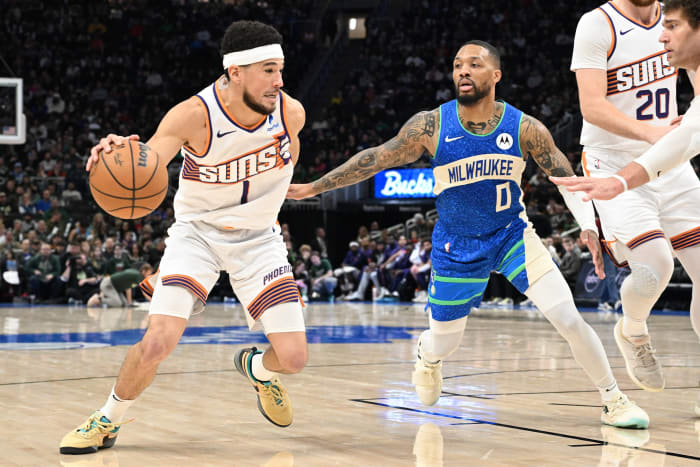 Phoenix Suns guard Devin Booker (1) drives to the basket against Milwaukee Bucks guard Damian Lillard (0)